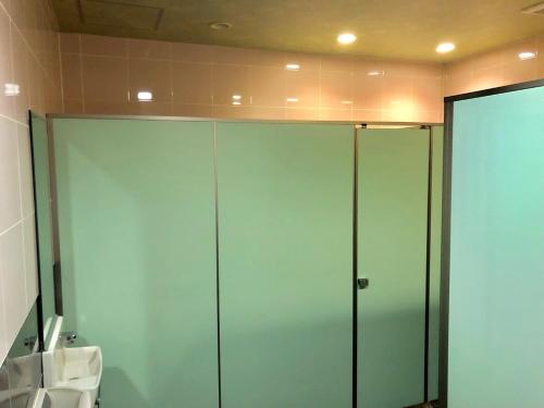 two glass doors in a bathroom with a toilet at Capsule Hotel Block Room in Tokyo
