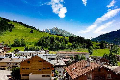 une petite ville avec une colline verdoyante et des maisons dans l'établissement Studio Panorama - Vue montagne et village, Centre la Clusaz - AravisTour, à La Clusaz
