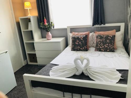 ロンドンにあるTrinity House Hotelのハートデコレーションの白いベッドが備わるベッドルーム1室