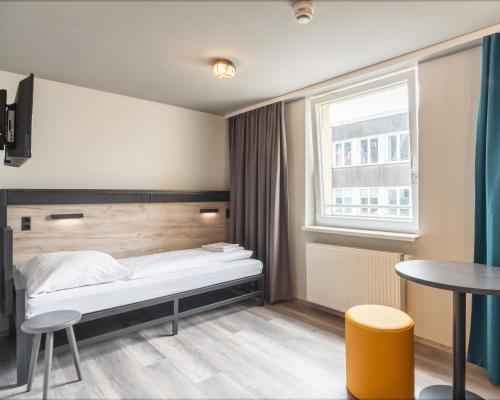 a bedroom with a bed and a window at a&o Frankfurt Galluswarte in Frankfurt
