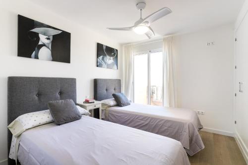 a bedroom with two beds and a window at Atico en playa muchavista san juan Estrella in El Campello
