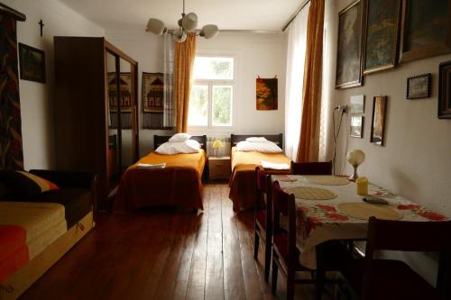 a room with two beds and a table and a window at Chata Pod Kamieniem in Jaśliska
