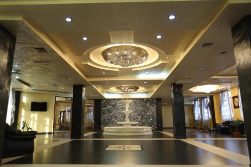 a lobby with a large chandelier in a building at Vanatur Hotel in Gyumri