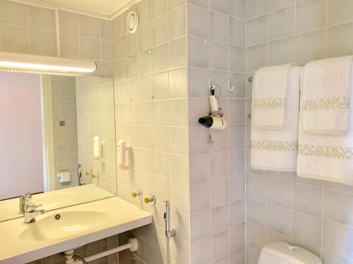 y baño con lavabo, aseo y toallas. en Hotelli Mesku Forssa en Forssa