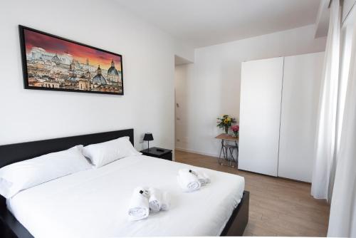 a bedroom with a white bed and a painting on the wall at St. Paul Palace Relais in Rome