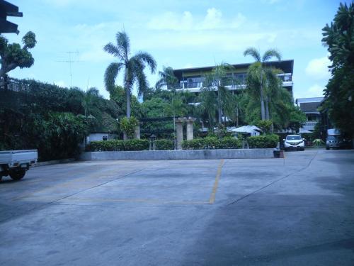 a parking lot in front of a building with palm trees at Lantana Pattaya - SHA Extra Plus in Pattaya North