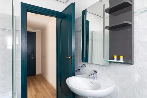 ein Badezimmer mit einem weißen Waschbecken und einer blauen Tür in der Unterkunft B&B Hotel Como City Center in Como