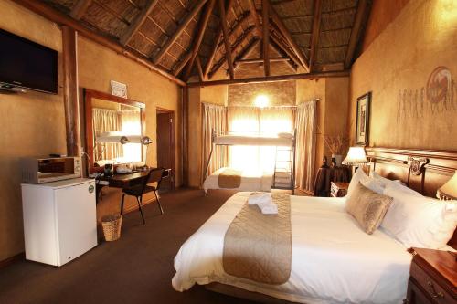 una camera d'albergo con un grande letto e una scrivania di Kuruman Inn a Kuruman