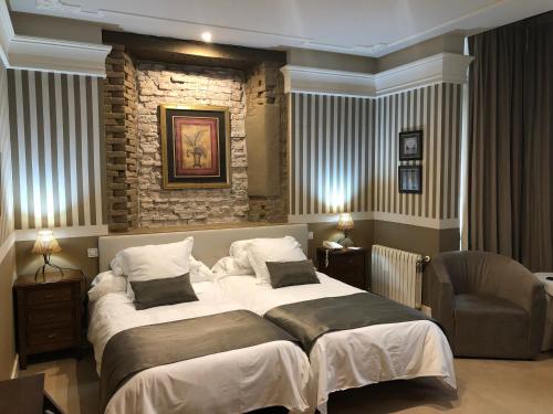 a bedroom with two beds and a stone wall at Marina de Campios in Comillas