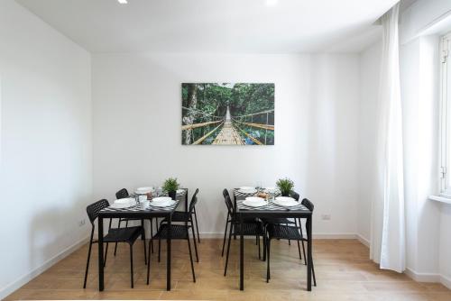 a dining room with black tables and chairs and a painting at St. Paul Palace Relais in Rome