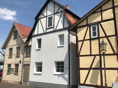a white and black building with a street light at Ferienhaus Am Fulda Ufer in Rotenburg an der Fulda