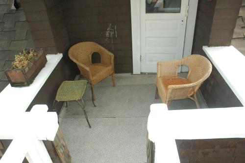 a porch with two chairs and a white door at Windsor Guest House in Vancouver