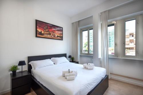 una camera da letto con un grande letto bianco con due asciugamani di St. Paul Palace Relais a Roma