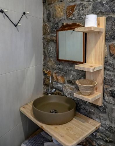 a bathroom with a sink and a stone wall at Pefkos Eye in Pefki Rhodes