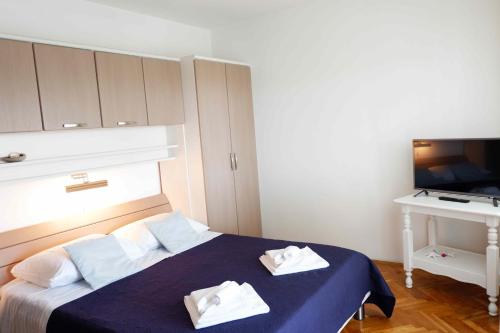 a bedroom with a bed with two towels on it at Apartment Ponoš in Krk