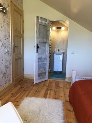 a room with a bathroom with a door and a sink at ALANTOS ŽIRGAI Holiday Villas sauna or hottube additional price in Alanta