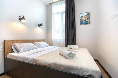 ein Schlafzimmer mit einem Bett mit zwei Handtüchern darauf in der Unterkunft Wehost Apartment for 3 in Tbilisi City
