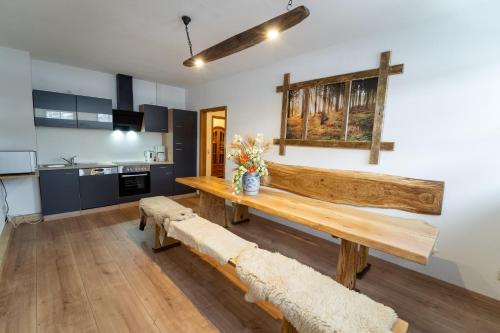 uma cozinha com uma mesa de madeira e banco num quarto em Ankerbräu Ferienwohnungen Brauerei Bierbad em Steinach