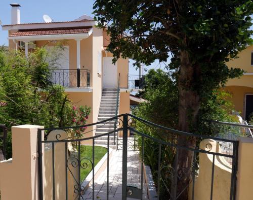 a staircase leading to a house with a tree at Moraitika Old Village Apartments in Moraitika