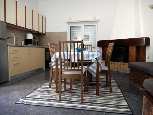 a kitchen with a table and chairs in a kitchen at Moraitika Old Village Apartments in Moraitika