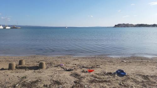 a sand castle on a beach next to the water at Apartments Babic in Podstrana