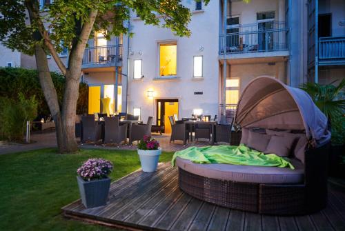 a bed sitting on a wooden deck in a yard at Auenwald Hotel und Apartmenthaus in Leipzig