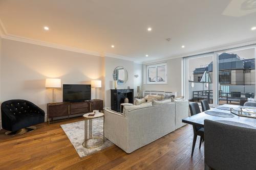 a living room with a couch and a television at ALTIDO Luxury 2 bed flats with terraces near Piccadilly Circus in London