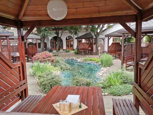 an outdoor patio with a table and a pond at Hotel U Racka in Ostrožská Nová Ves