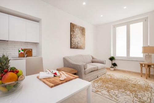 a white living room with a table and a couch at Divo Apartments - Spanish Steps in Rome