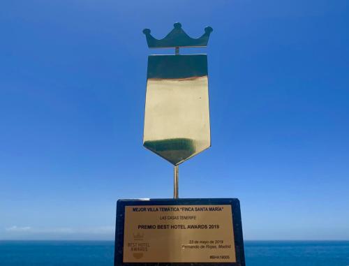 a trophy with a sign in front of the ocean at Finca Santa Maria in Callao Salvaje