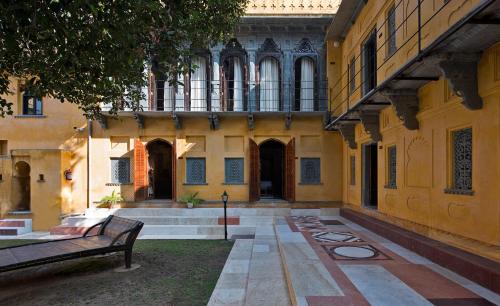 an empty courtyard of a building with a bench at Gogunda Palace in Udaipur