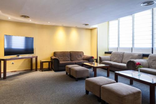 a waiting room with couches and a flat screen tv at Hotel Don Paco in Seville