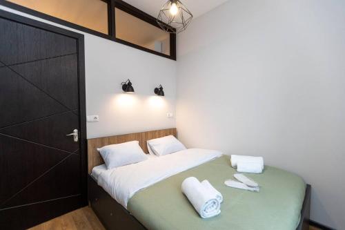 1 dormitorio con 1 cama y 2 toallas blancas en Wehost Apartment With 3 Bedrooms, en Tiflis