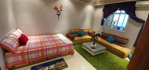 a room with two beds and a couch and a window at App Khouribga in Khouribga