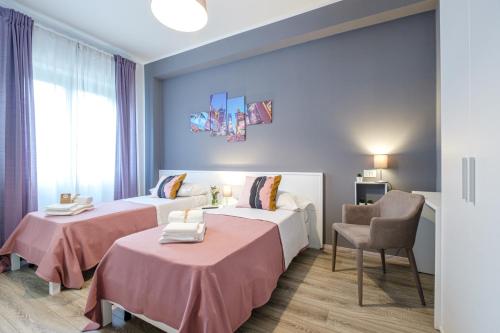 una habitación de hotel con 2 camas y una silla en HOME52, en Rende