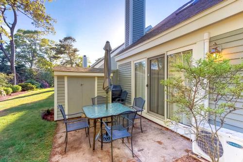 a patio with a table and chairs next to a house at Ocean Edge Retreat in Brewster