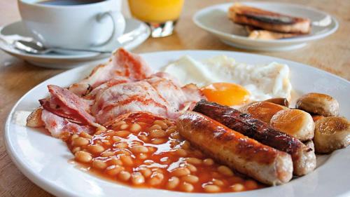 a plate of breakfast food with eggs sausage and beans at Royal Britannia Hotel in Ilfracombe