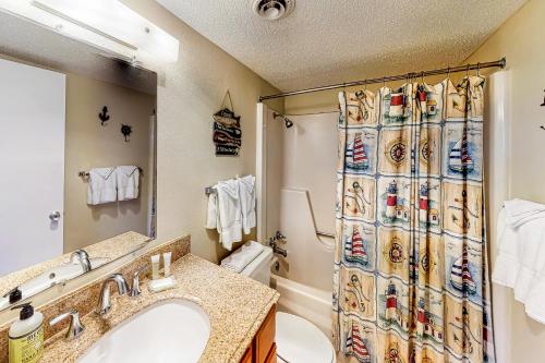 a bathroom with a sink and a toilet and a shower curtain at Solare Garden Villa #773 in South Padre Island