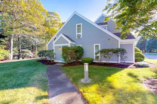 a gray house with a sidewalk in front of a yard at Ocean Edge Retreat in Brewster