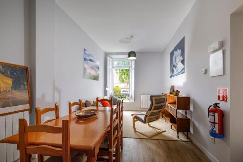 a dining room with a wooden table and chairs at Apartamentos CASA CARRE 1893 in Santoña