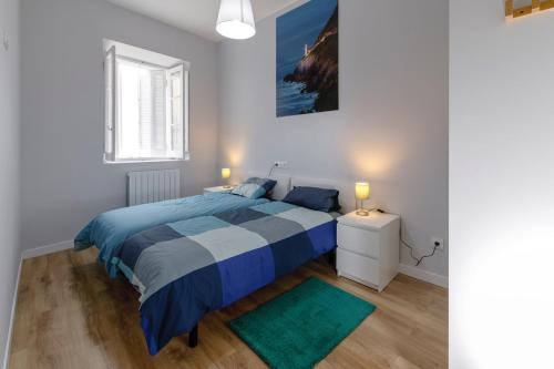 a bedroom with a bed and a green rug at Apartamentos CASA CARRE 1893 in Santoña