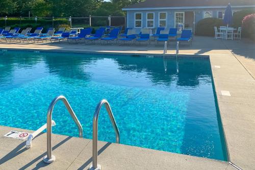 a swimming pool with blue lounge chairs and a swimming pool at Ocean Edge Retreat in Brewster
