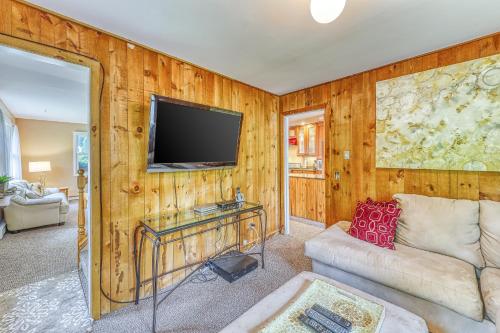 a living room with a couch and a flat screen tv at Sugarbush River Home in Warren