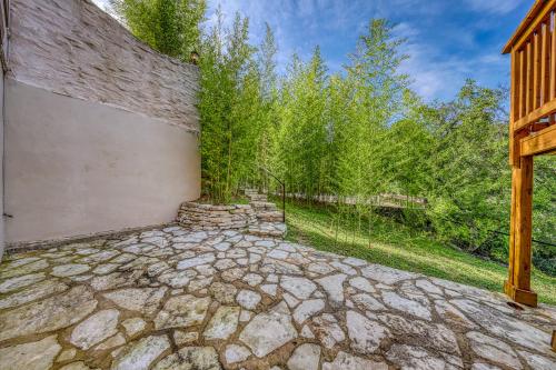 a stone walkway in front of a building with trees at Peaceful Retreat on Quiet Cove on Lake Travis in Lakeway