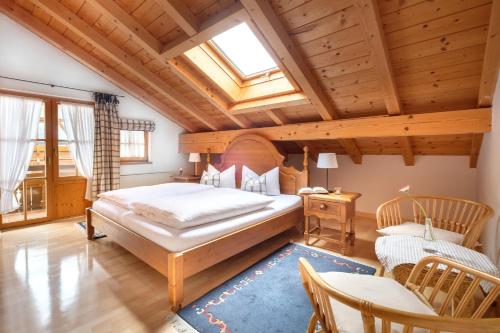 a bedroom with a large bed and a wooden ceiling at Die Edelraute in Oberstdorf