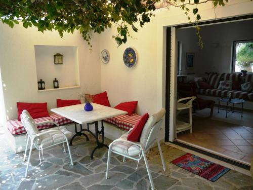 a room with a table and chairs and a living room at Blumenhaus (Spiti Louloudia) in Paralía Sergoúlas