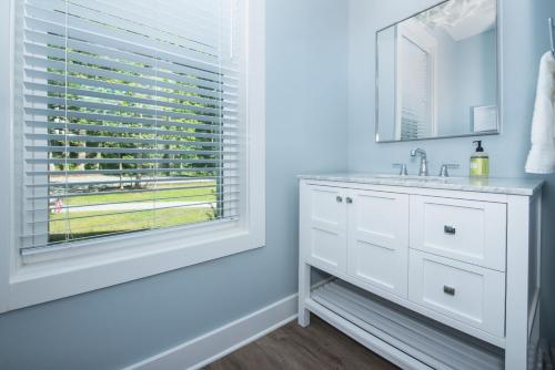 a white bathroom with a sink and a window at Pebble Beach in Bumpass