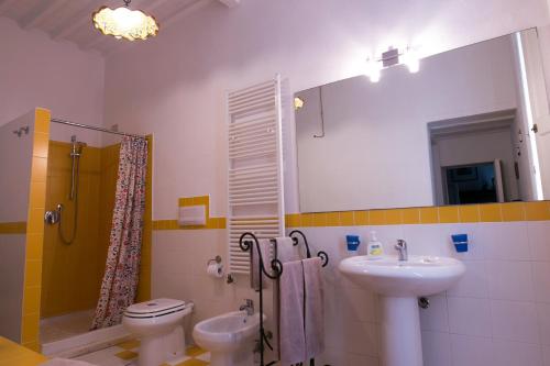 ein Badezimmer mit einem Waschbecken, einem WC und einem Spiegel in der Unterkunft Relais Sassetti in Pisa