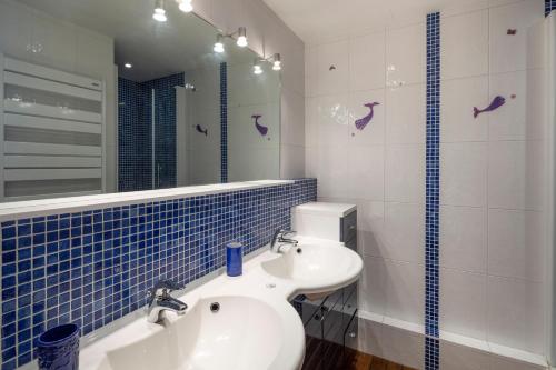 a bathroom with a sink and a mirror at La Bisquine - Appt pour 4 avec vue mer in Cancale