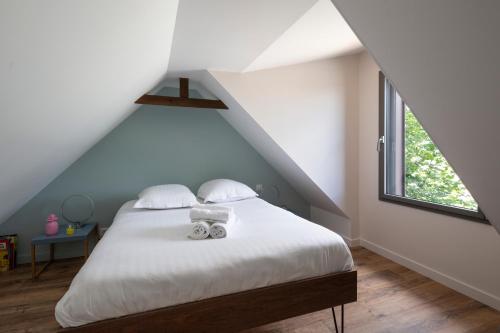 une chambre avec un lit avec des draps blancs et une fenêtre dans l'établissement L'Ernestine - Belle maison pour 4 dans Rennes, à Rennes